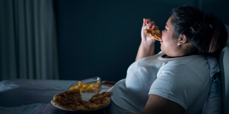 female eating abnormal amounts of food depicting Obesity